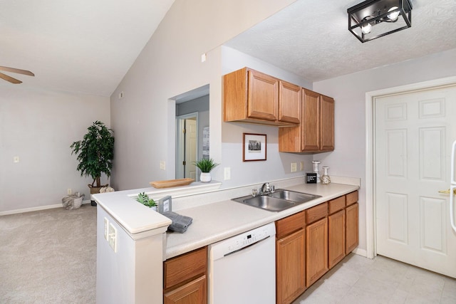 kitchen with white dishwasher, a sink, light countertops, ceiling fan, and vaulted ceiling