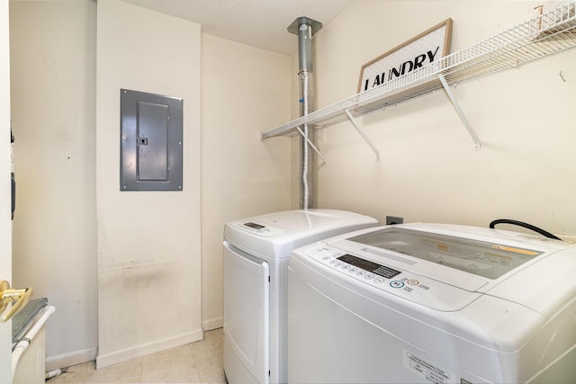 washroom with electric panel, washing machine and dryer, baseboards, and light tile patterned flooring