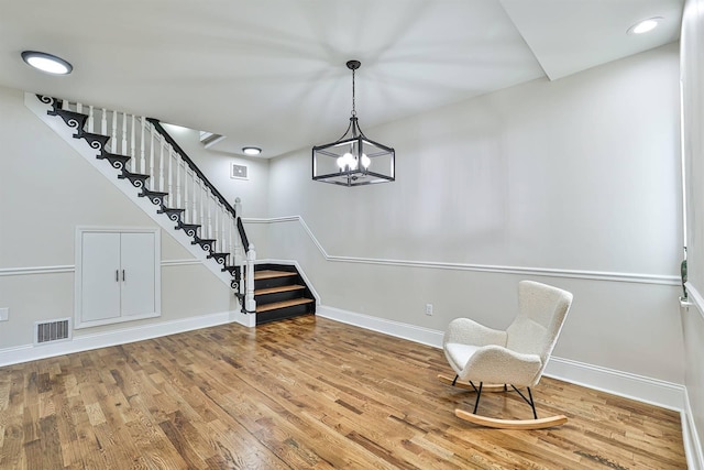 entrance foyer with stairs, wood finished floors, baseboards, and a chandelier