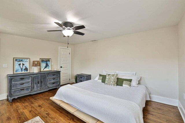 bedroom with baseboards, dark wood-type flooring, and ceiling fan