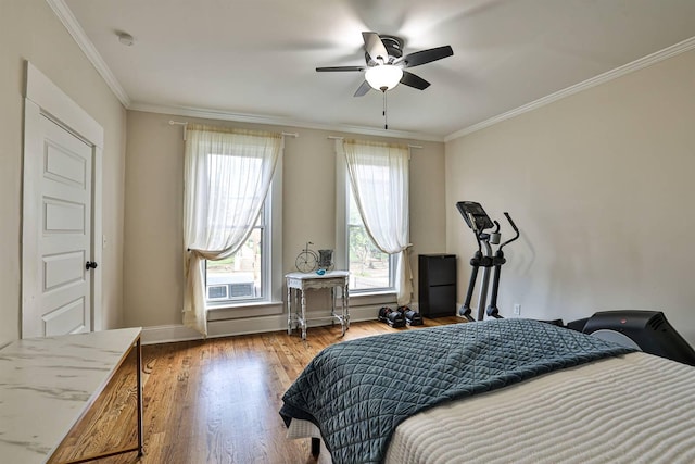 bedroom with wood finished floors, crown molding, ceiling fan, and baseboards