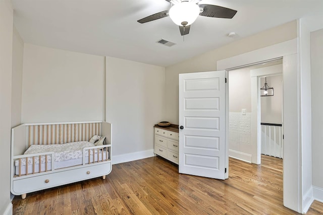 bedroom featuring wood finished floors, baseboards, and a ceiling fan