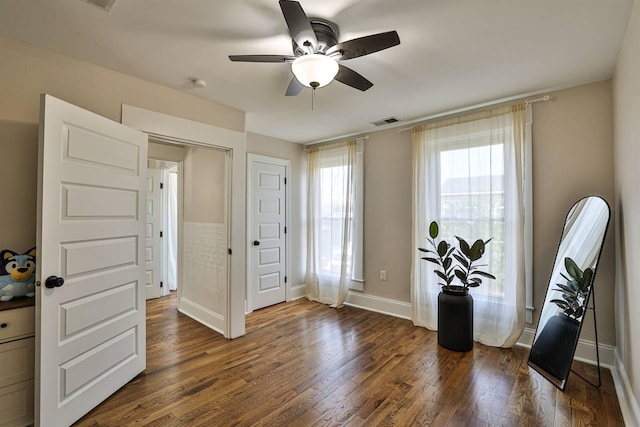foyer entrance featuring ceiling fan, dark wood finished floors, and baseboards