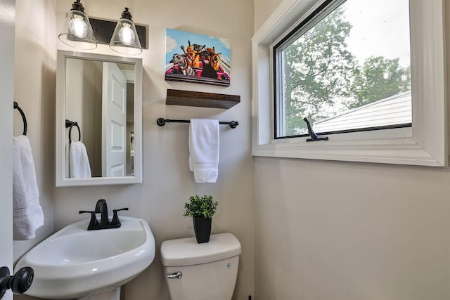 half bathroom featuring a sink and toilet