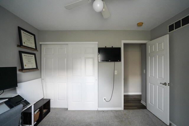 unfurnished bedroom featuring carpet flooring, a closet, ceiling fan, baseboards, and an office area