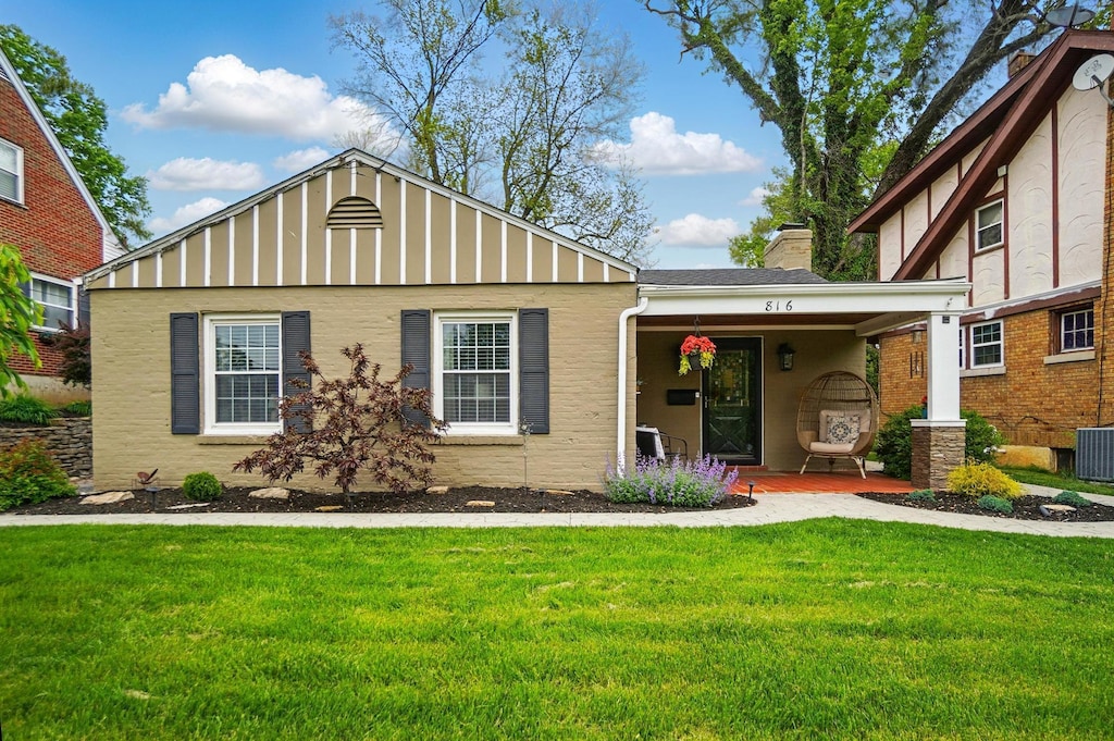 816 Aberdeen Rd, Covington, KY 41011 - view of front of property featuring a front lawn, covered porch, a chimney, stucco siding, and cooling unit