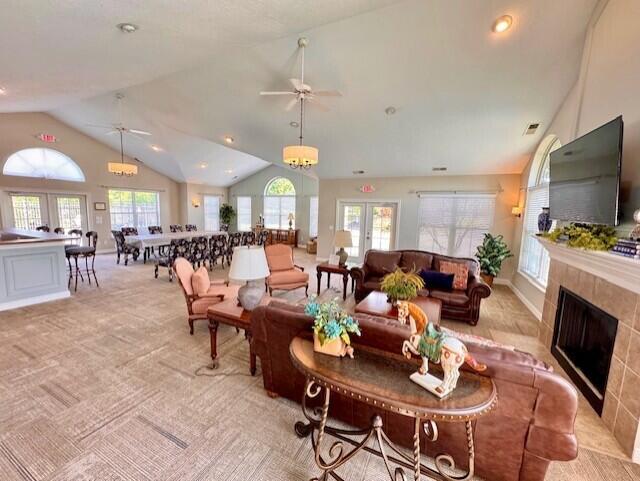 living room featuring lofted ceiling, ceiling fan, a fireplace, light colored carpet, and recessed lighting