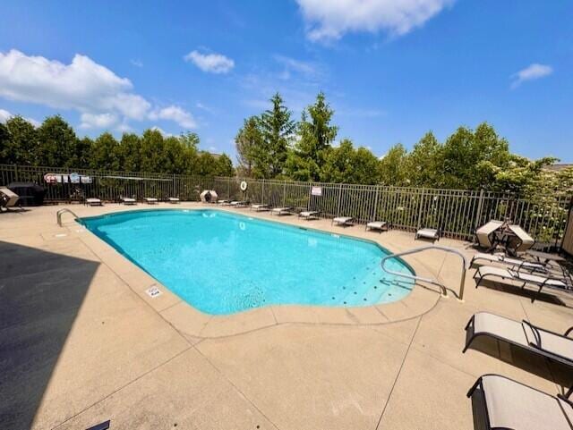 community pool featuring a patio and fence