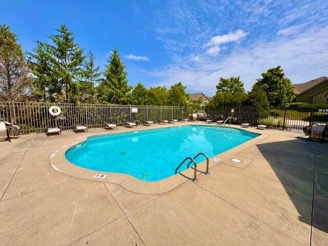 community pool featuring a patio and fence