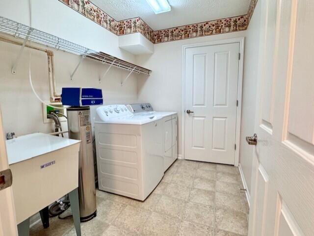 laundry area with washing machine and dryer and water heater