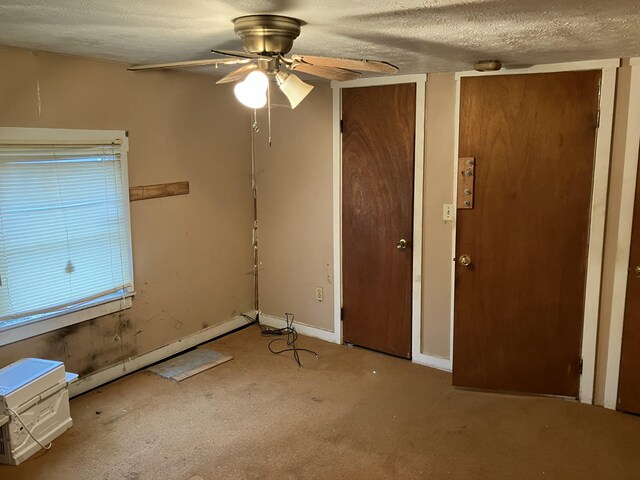 4910 Fowler Creek Rd, Covington, KY 41017 - unfurnished bedroom featuring carpet, a textured ceiling, baseboards, ceiling fan, and multiple closets