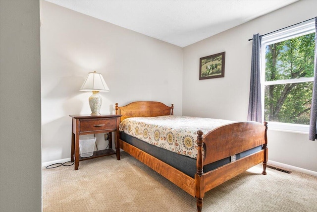 bedroom with light carpet and baseboards