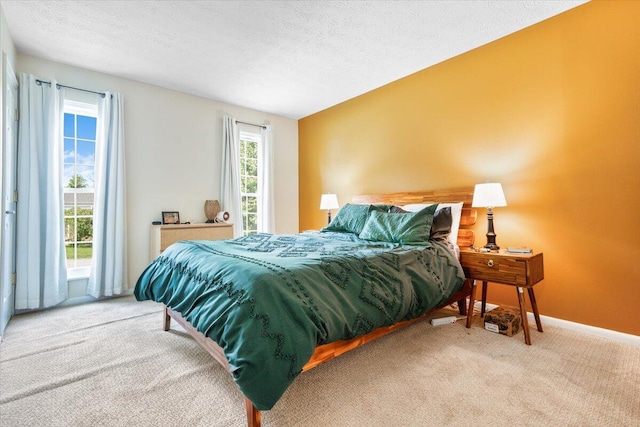 bedroom with carpet flooring, a textured ceiling, and baseboards