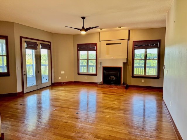 410 Links View Dr, Butler, KY 41006 - unfurnished living room featuring wood finished floors, a fireplace with raised hearth, and a ceiling fan