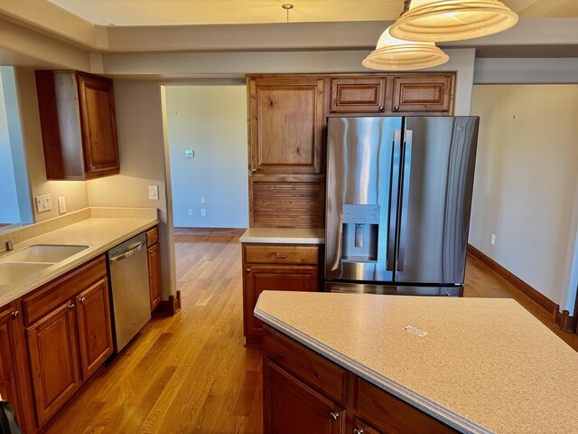 410 Links View Dr, Butler, KY 41006 - kitchen with stainless steel appliances, a sink, wood finished floors, light countertops, and brown cabinetry