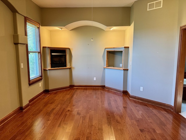 410 Links View Dr, Butler, KY 41006 - spare room featuring wood finished floors, baseboards, a fireplace, and arched walkways