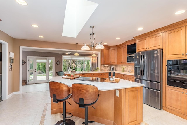 1051 Arden Dr, Villa Hills, KY 41017 - kitchen with stainless steel appliances, light countertops, light tile patterned floors, a skylight, and recessed lighting