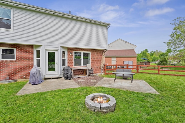 back of property featuring a patio area, a fire pit, and brick siding