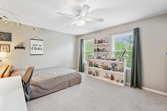 carpeted bedroom with ceiling fan and baseboards