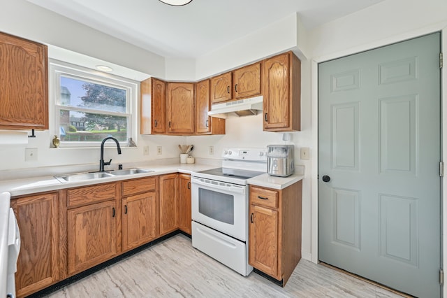 kitchen with white electric range, a sink, under cabinet range hood, brown cabinets, and light countertops