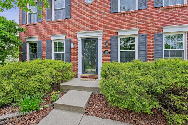 view of exterior entry featuring brick siding