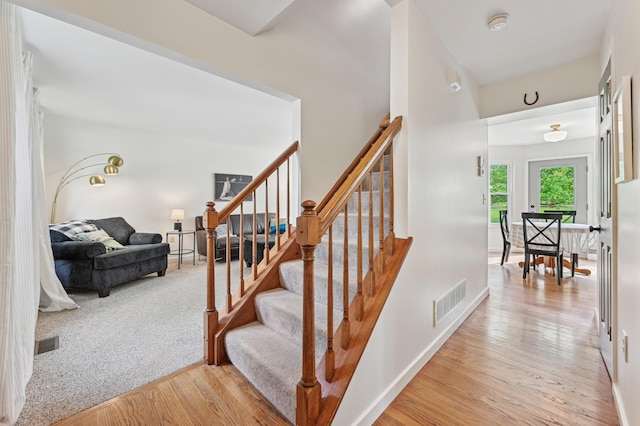 staircase featuring wood finished floors and baseboards