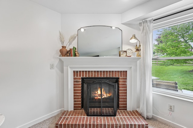 detailed view of baseboards, a fireplace, and carpet floors