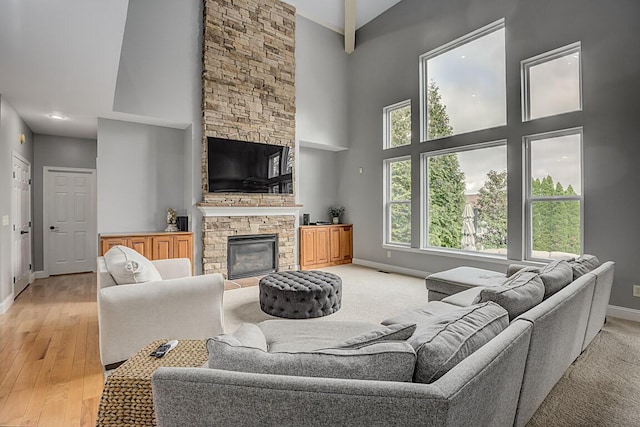 2282 Treetop Ln, Hebron, KY 41048 - living room with high vaulted ceiling, baseboards, a stone fireplace, and light wood-style floors