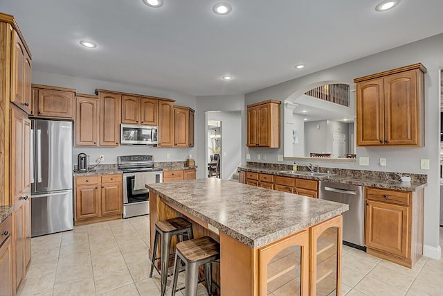 2282 Treetop Ln, Hebron, KY 41048 - kitchen featuring stainless steel appliances, a sink, a kitchen island, a breakfast bar, and light tile patterned floors