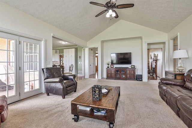living area with carpet flooring, vaulted ceiling, a ceiling fan, and a textured ceiling