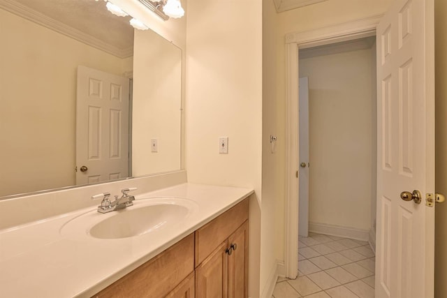 bathroom with tile patterned floors, vanity, ornamental molding, and baseboards