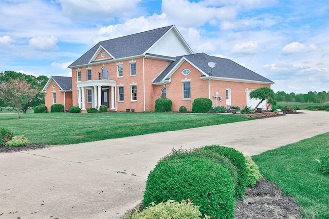 colonial inspired home with brick siding and a front lawn