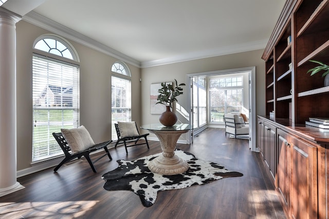 living area featuring ornate columns, ornamental molding, dark wood-style flooring, and baseboards
