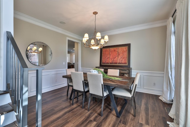 dining area with a chandelier, ornamental molding, a wainscoted wall, dark wood-type flooring, and a decorative wall