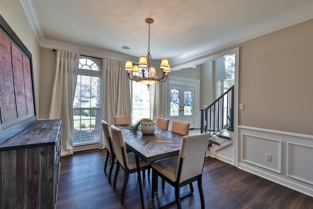 dining space featuring ornamental molding, a chandelier, healthy amount of natural light, dark wood finished floors, and stairway