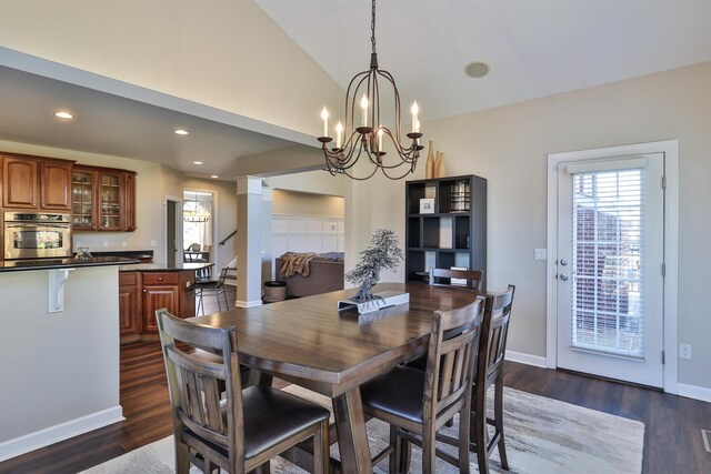 dining area featuring a chandelier, lofted ceiling, dark wood-style floors, recessed lighting, and baseboards
