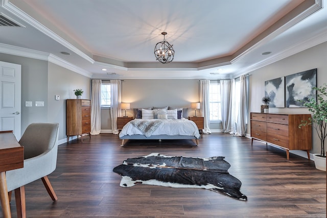 bedroom featuring a tray ceiling, crown molding, baseboards, a chandelier, and dark wood-type flooring