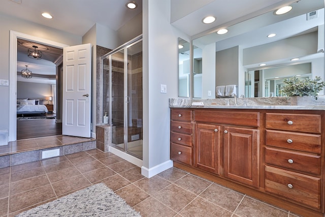 ensuite bathroom featuring a shower stall, vanity, baseboards, tile patterned floors, and recessed lighting