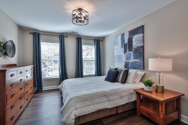 bedroom with dark wood-style flooring and baseboards
