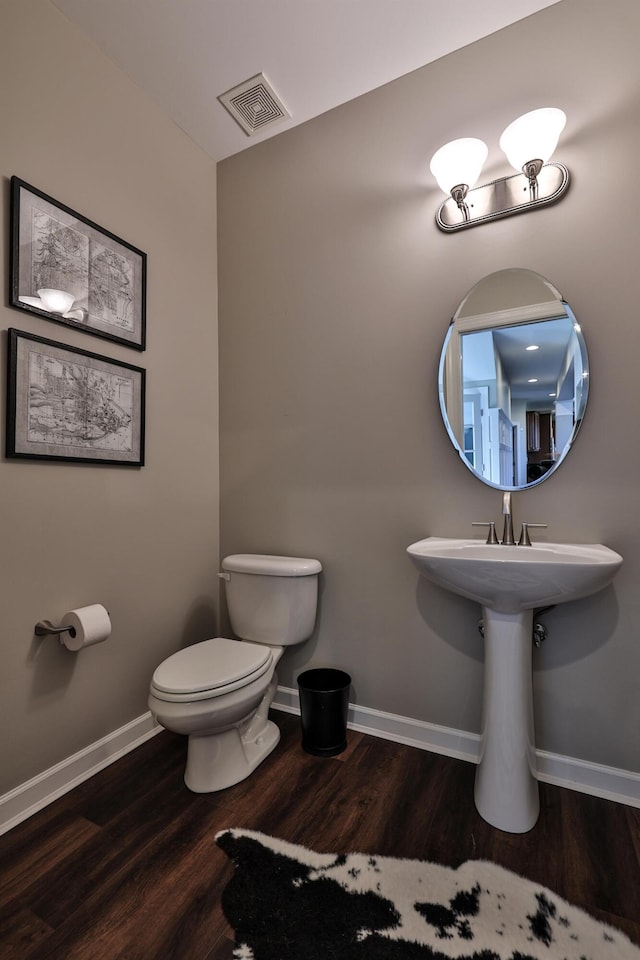 bathroom featuring wood finished floors, toilet, and baseboards