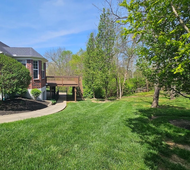 view of grassy yard featuring stairway and a wooden deck