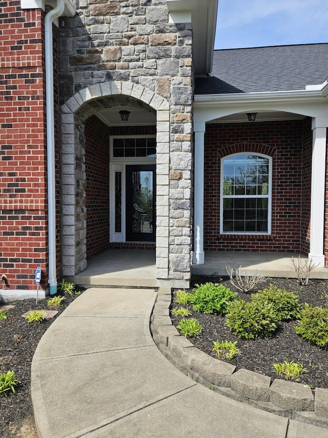 property entrance with stone siding and brick siding