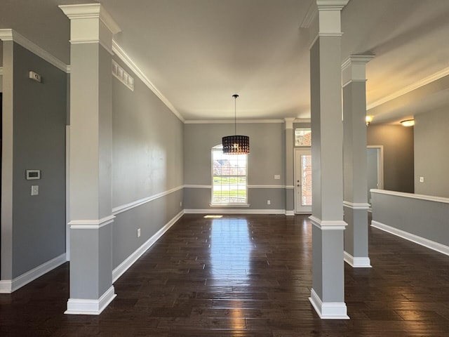 unfurnished dining area featuring decorative columns, dark wood finished floors, baseboards, and ornamental molding