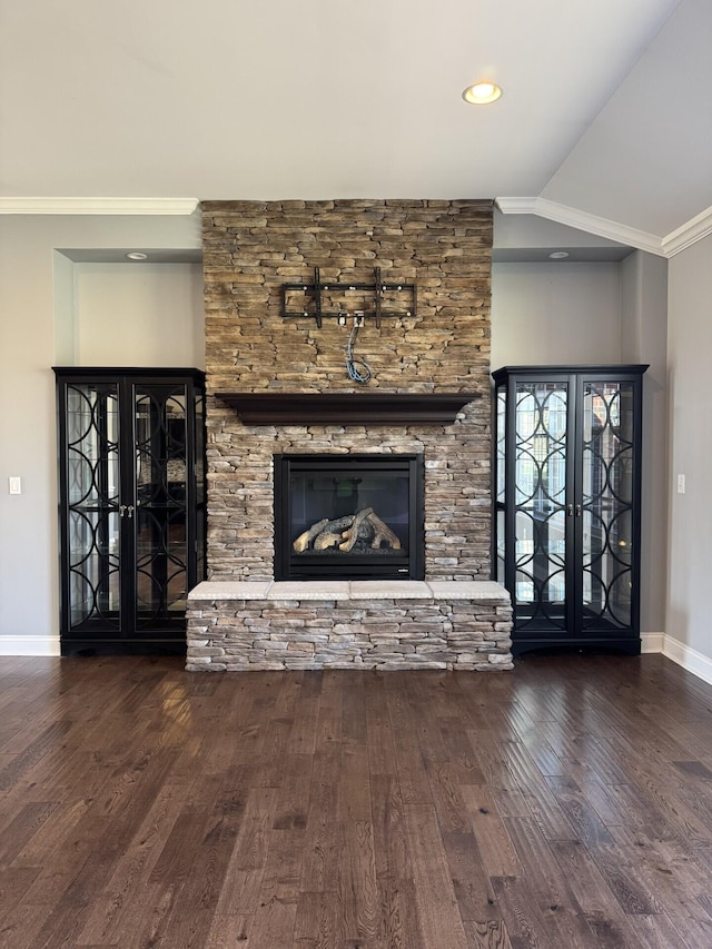 unfurnished living room with ornamental molding, wood finished floors, baseboards, a fireplace, and vaulted ceiling