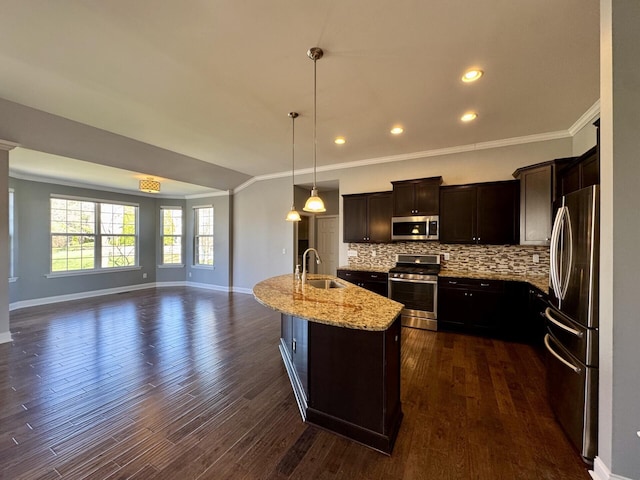 kitchen featuring appliances with stainless steel finishes, ornamental molding, a sink, baseboards, and light stone countertops