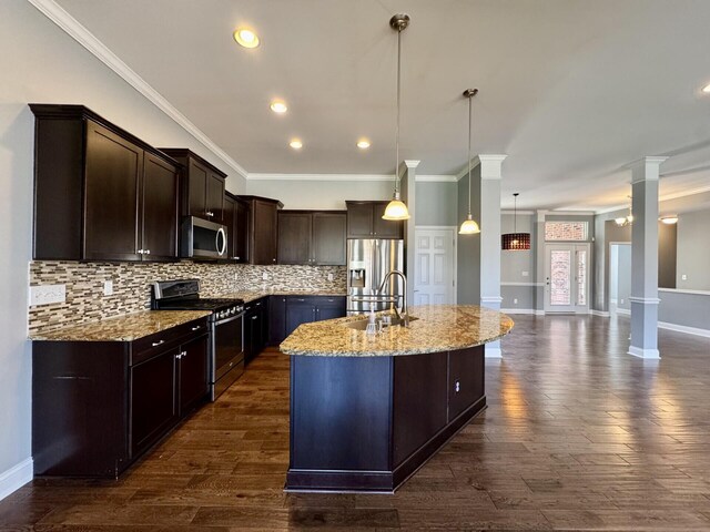 kitchen featuring appliances with stainless steel finishes, a sink, dark brown cabinetry, open floor plan, and decorative backsplash