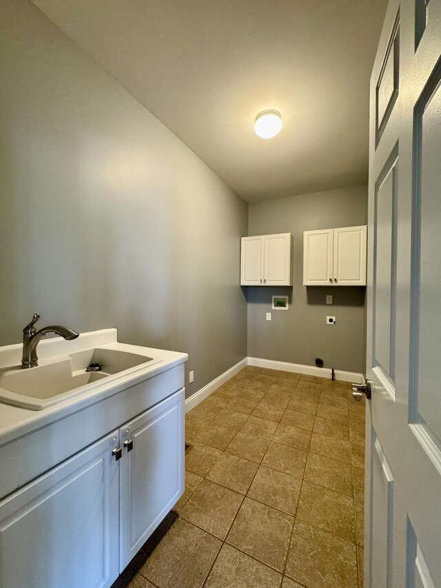washroom with washer hookup, cabinet space, hookup for an electric dryer, baseboards, and dark tile patterned flooring