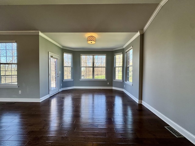 unfurnished room featuring ornamental molding, healthy amount of natural light, baseboards, and dark wood finished floors