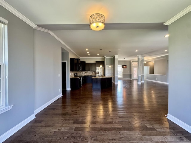unfurnished living room with dark wood finished floors, baseboards, ornate columns, ornamental molding, and recessed lighting