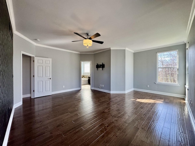 spare room featuring a ceiling fan, healthy amount of natural light, dark wood finished floors, and crown molding